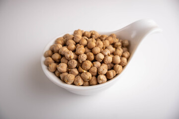raw chickpeas in a bowl on a white background