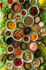 Brightly colored spices and herbs arranged on a delicate green background, highlighting their freshness and fragrance for a lively, natural look