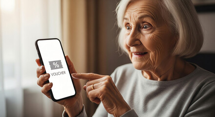 Happy senior woman using a smartphone to claim a digital discount voucher for online shopping, showcasing modern tech-savvy elderly