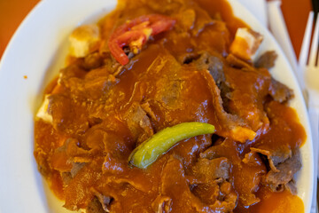 Close-Up of Turkish Iskender Kebab with Doner Meat on a White Plate
