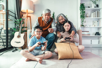 Family Playing Video Game Together in Cozy Living Room with Grandparents and Children Sharing Joyful Leisure Activity and Generational Bond