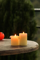 Autumn Pumpkins with Candles – Halloween Decoration. Cozy Halloween scene with autumn pumpkins, candles, and festive miniatures in a basket. Rustic wooden table and soft mysterious daylight create sea