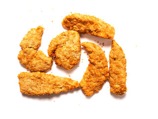 Uncooked chicken goujons or tenders in on white background. Popular classic chicken dish made from pieces of breast and breadcrumbs. Traditional ready to cook poultry product.