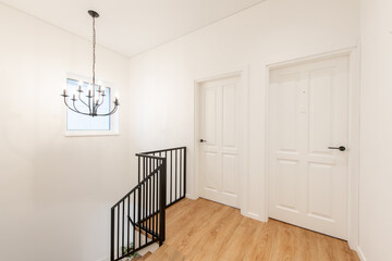 Bright Home House Hallway with Wooden Flooring and Modern Black Staircase Design