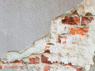 background. wall with chipped plaster and visible red bricks. Copy space 