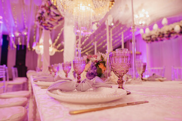 elegant table decorated with a large lamp and plates and purple flowers