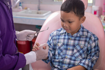 Close up dentist hand examining patient tooth on dental chair. Professional dentist making teeth cleaning patient at the dental office.