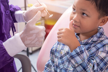 Close up dentist hand examining patient tooth on dental chair. Professional dentist making teeth cleaning patient at the dental office.