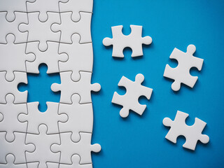 Obraz premium Solving complex business problems with a modern white puzzle on blue background illustrating strategy and creative solutions