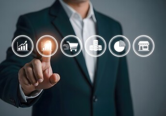 Man in suit pointing at glowing chart icon among other business related icons in a digital display