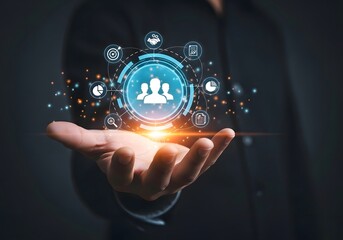 Person holding a glowing circle with team icon and business icons floating around it on dark background