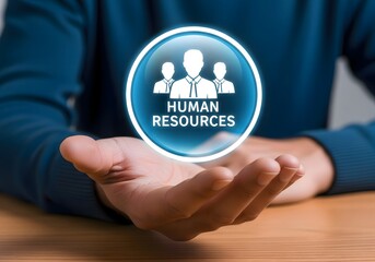 Person holding a glowing human resources icon in their hand on a wooden surface background view