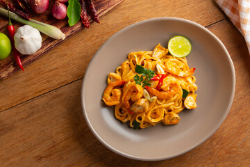Creamy Fettuccine pasta Tom Yum Kung,Thai style fusion food, spicy spaghetti with shrimp and straw mushroom in tom yum sauce.Top view.