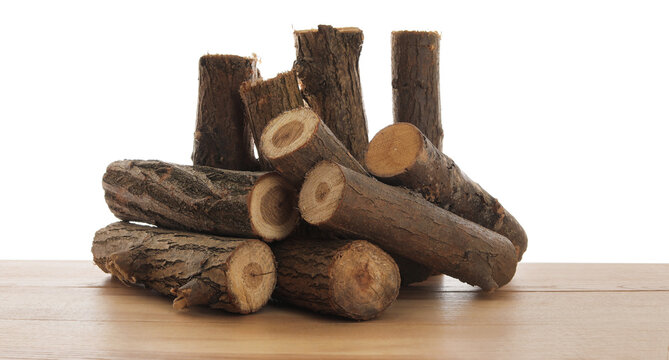 Pile of cut firewood on wooden table against white background - Powered by Adobe