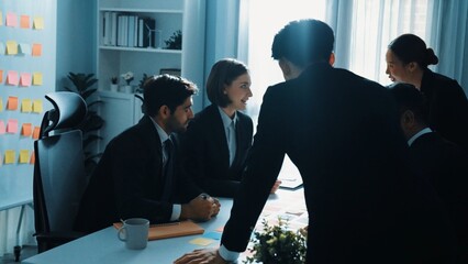 Executive manager enter meeting while team discuss and brainstorm idea about marketing plan by using sticky notes. Group of diverse people working together to solve business problems. Directorate.