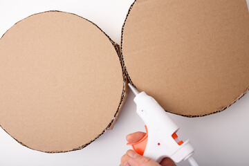 DIY cardboard construction with hot glue gun in action, ideal for craft tutorials, packaging design, educational materials, eco-friendly branding, and maker-focused business visuals,