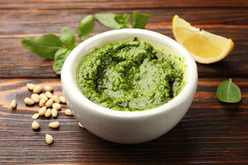 Fresh pesto sauce and ingredients on wooden table, closeup