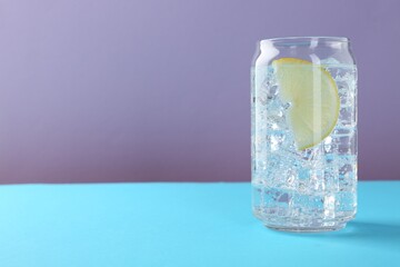 Refreshing water with lemon and ice on color background. Space for text