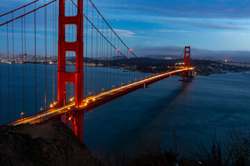 A long exposure shot of the Golden Gate Bridge at night, showing the light trails of cars moving across the bridge.