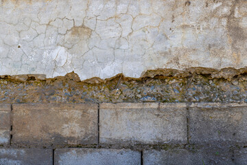 Weathered plastered and brick wall showing damage under sun light