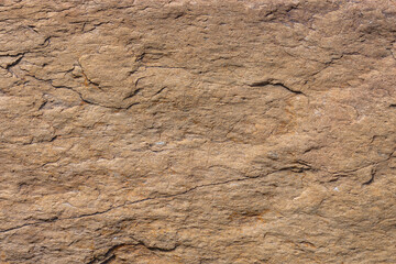 Rugged beige sedimentary rock formation in natural outdoor setting during daytime