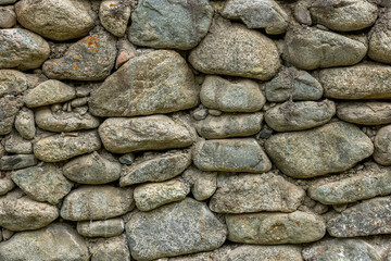 Rustic stone wall in rural outdoor setting during daytime