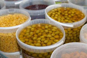 Containers of Marinated Green Olives on Display at a Market