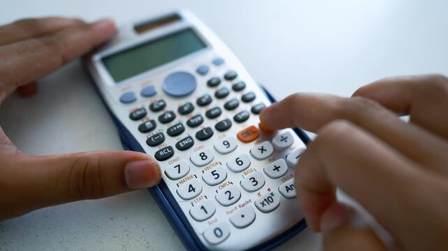 Hands Using Scientific Calculator on White Surface, Close-up of hands using a scientific calculator on a white surface