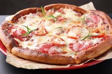 Delicious pizza with cheese and salami on dark wooden table, closeup