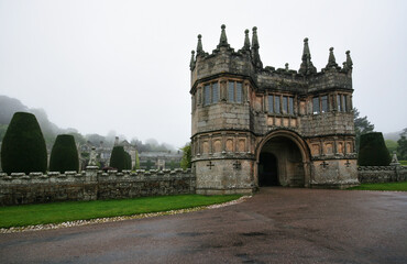 Obraz premium Main entrance gate at Lanhydrock House, moody typical english weather with fog in distance