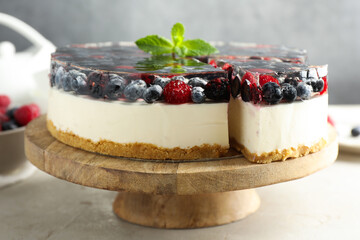 Delicious cheesecake with berries and mint on light grey table, closeup