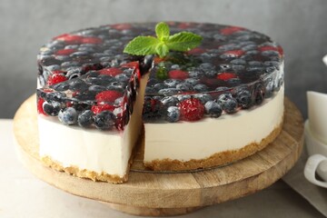 Delicious cheesecake with berries and mint on light grey table, closeup
