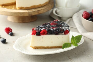 Piece of delicious cheesecake with berries and mint on light grey table, closeup