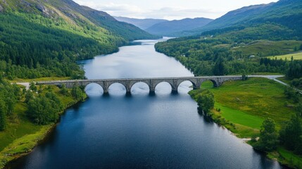 Aerial View of a Stone Arch Bridge Spanning a Serene River in a Green Valley