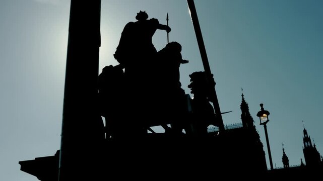 Silhouette of Boadicea and Her Daughters statue at Westminster against the sun, iconic monument, Houses of Parliament, dramatic light, city landmark.
