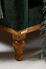 Close-up of a wooden furniture leg and furniture brand label.