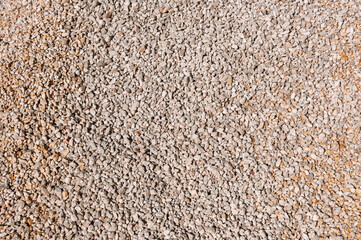 Detail view of crushed limestone aggregate texture, a perfect background for construction, geology, and landscaping projects. Neutral colors and uniform lighting.