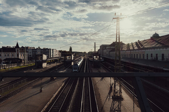 Train station at sunrise with tracks and architecture

