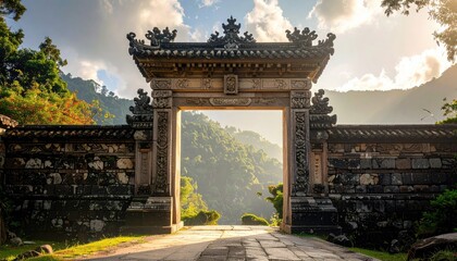 Obraz premium Ornate Stone Temple Gate with Curved Roof in Lush Greenery Under Bright Sky with Mountains in Distance in Sunny Weather