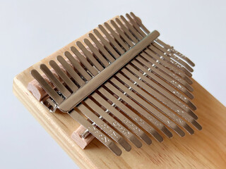 Close-up of a wooden kalimba with metallic tines on a wooden base