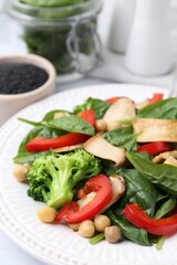Tasty salad with eryngium mushrooms, chickpeas, vegetables and spinach on table, closeup