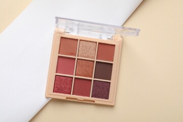 Beautiful eyeshadow palette on beige background, top view