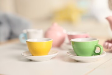 Tea set on white table indoors, closeup with space for text. Child's toy