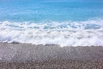 Beautiful view of wavy sea and pebbles on beach