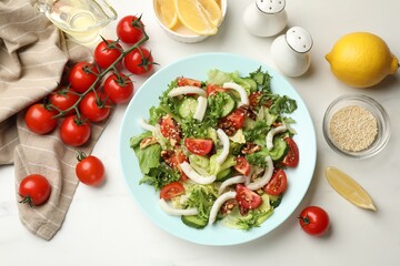 Delicious squid salad served on white table, flat lay