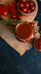 Tomato sauce in a jar with fresh tomatoes and rosemary.