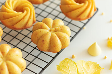 Autumn-Themed Mini pumpkin Cakes with Seasonal Decorations on White Background