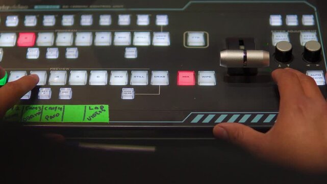 Video switcher operator working on live production broadcast console