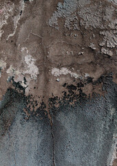 Close-up of old peeling paint on a wall surface. Weathered, cracked and flaking layers create a textured and distressed background.