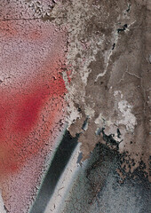 Close-up of old peeling paint on a wall surface. Weathered, cracked and flaking layers create a textured and distressed background.